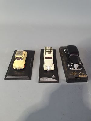 three different model cars on display on a table