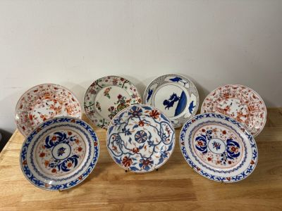six assiettes ornées de motifs différents, posées sur une table en bois
