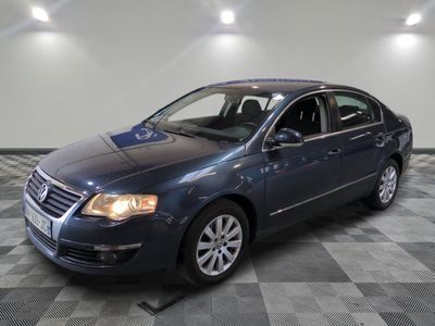 La Volkswagen Passat bleue est garée sur un sol en carreaux à damier.