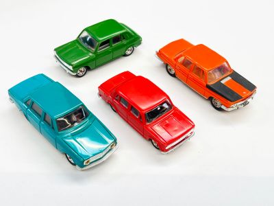 plusieurs petites voitures sont alignées sur une surface blanche