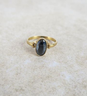 a gold ring with a black stone in the middle