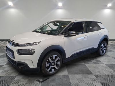 a white citrole is parked in a room with a checkered floor