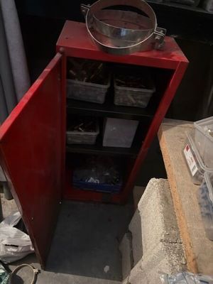 une armoire rouge sur laquelle est posé un saladier en métal