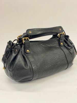 a black purse with gold hardware on the handle