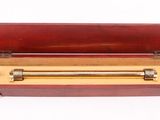 un vieux coffret en bois contenant une barre en laiton