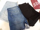 three pairs of jeans are laid out on a white surface