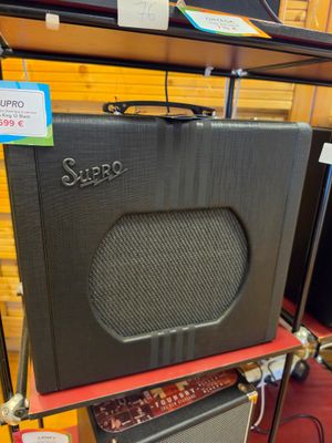 un ampli noir posé sur une étagère dans un magasin
