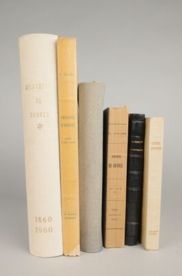 several books are stacked on top of each other on a gray surface