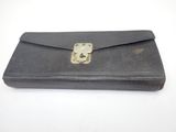 an old black leather wallet with a metal clasp on it
