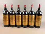 six bottles of wine lined up in a row on a table