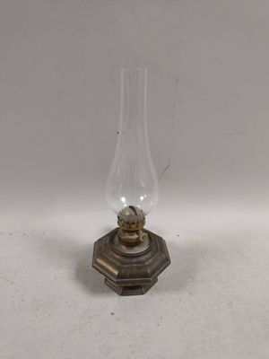 une lampe à huile à l'ancienne posée sur une table blanche