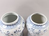 pair of blue and white vases sitting on top of a white surface