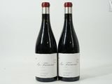 deux bouteilles de vin rouge posées l'une à côté de l'autre sur une surface blanche