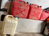 a pile of gas cans sitting on the side of a wall