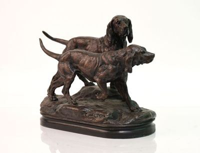 statue représentant deux chiens debout sur un rocher, posée sur un socle blanc