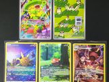 Quatre cartes Pokémon sont posées sur une surface noire