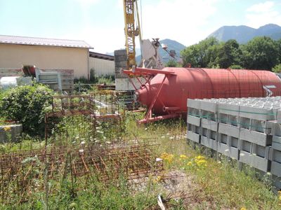 une grue qui se trouve à côté d'un tas de parpaings