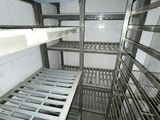 many racks of food in a kitchen that is dirty