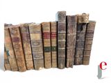 several old books are stacked on top of each other on a white surface