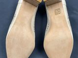 a pair of beige shoes on a blue surface