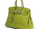 a green leather handbag on a white background