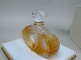 a glass perfume bottle sitting on top of a white box