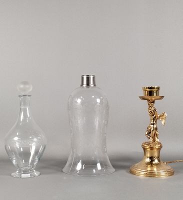 trois vases en verre et un bougeoir en laiton posés sur une table