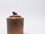 an image of a small wooden container with a bird on top of it
