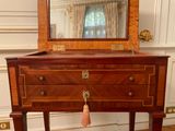 a small wooden table with a mirror on top of it