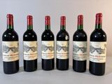 six bouteilles de vin rouge sont alignées sur une table