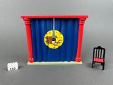 a toy chair and a chair in front of a curtain