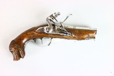 a small wooden gun that is on a white surface