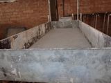 a metal bed in the middle of a room with a brick wall