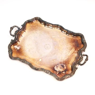 a silver tray with a handle on a white surface