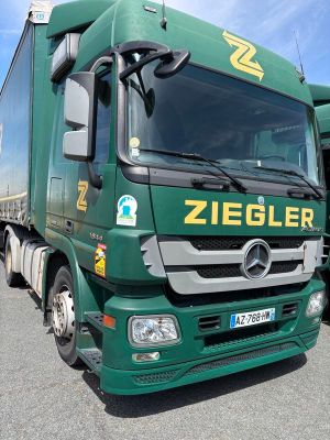 deux camions verts garés l'un à côté de l'autre sur un parking