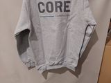 a grey sweatshirt with the word core on it hanging on a wall