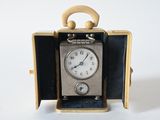 a small clock inside of a case on a white surface