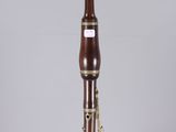 a close up of a wooden bassoon on display on a clear surface