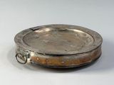a silver plate with a handle on a white surface