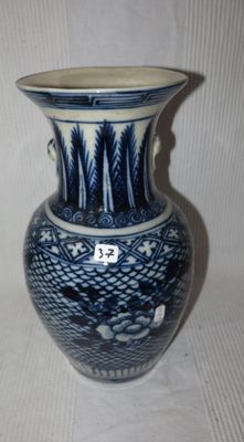 un vase bleu et blanc posé sur une surface blanche
