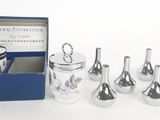 six glass vases in a blue box on a white surface