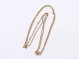 a close up of a gold necklace with a chain on a white surface