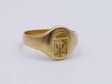 a close up of a gold ring with a crest on it