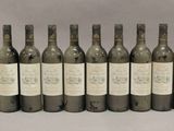 six bouteilles de vin sont alignées sur une table