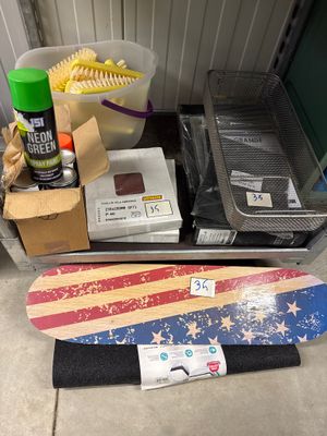 un skateboard posé par terre à côté d'autres objets