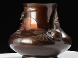 a brown vase sitting on top of a white table
