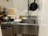 une petite cuisine équipée d'un évier et d'un micro-ondes fixé au mur