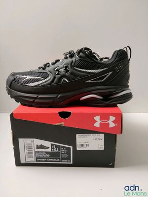 une paire de chaussures noires et rouges posée sur une boîte