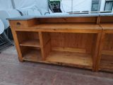 a wooden counter with a sink and shelves on it