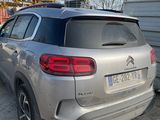 the rear end of a silver car parked in a parking lot